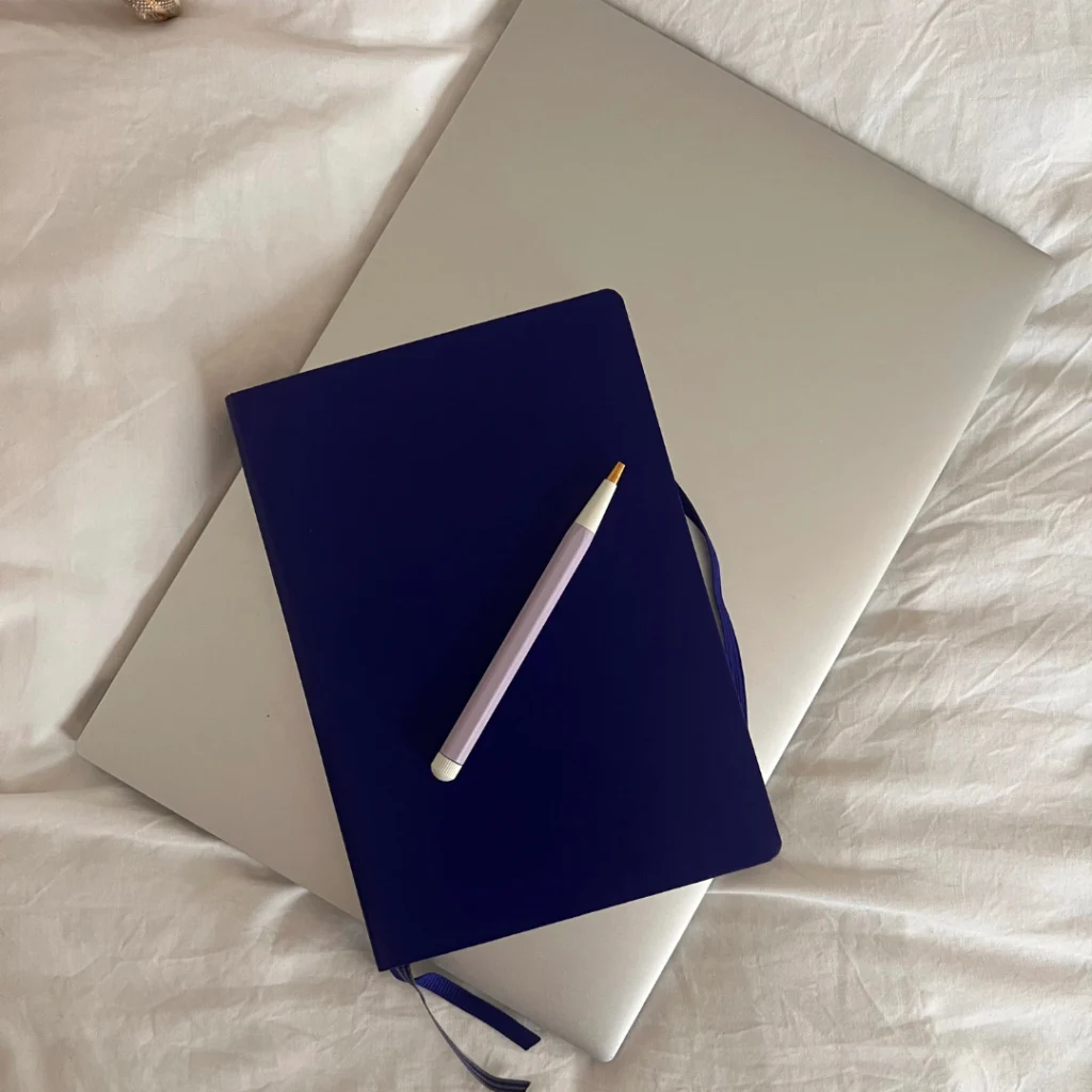 a notebook and pen on a laptop